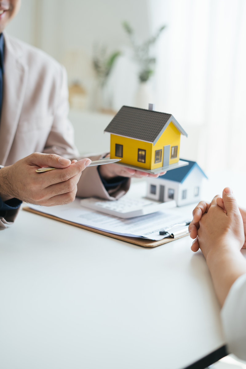 Real estate agent and realtor general liability insurance businessman professional discussing and consultant with house toy model building before sign a contract with law concept.