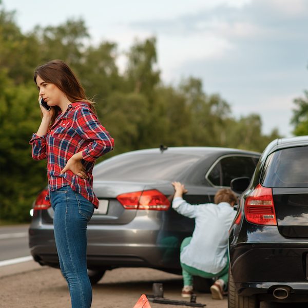 Male and female drivers on road, car accident. Automobile crash. Broken automobile or damaged vehicle, auto collision on highway